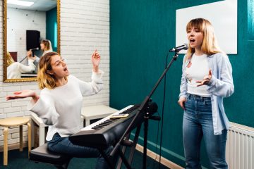 Woman singer rehearsing her song on a lesson with a teacher